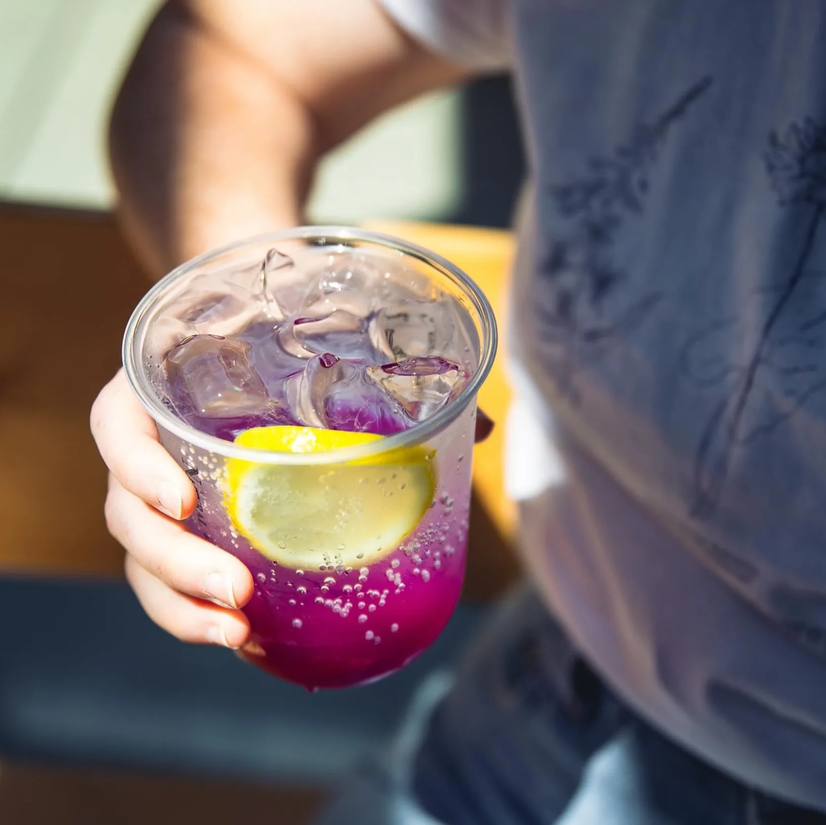 An iced butterfly pea lemonade in the sun at Good Kid Coffee