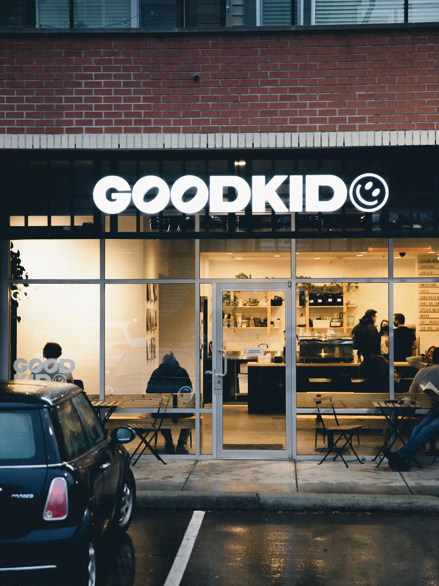The Good Kid Coffee storefront lit up at dusk